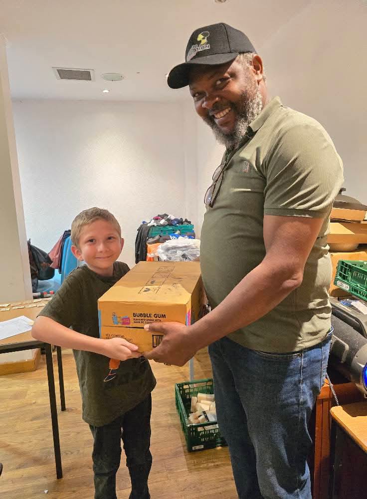 Adult and child holding a box of bubble gum together