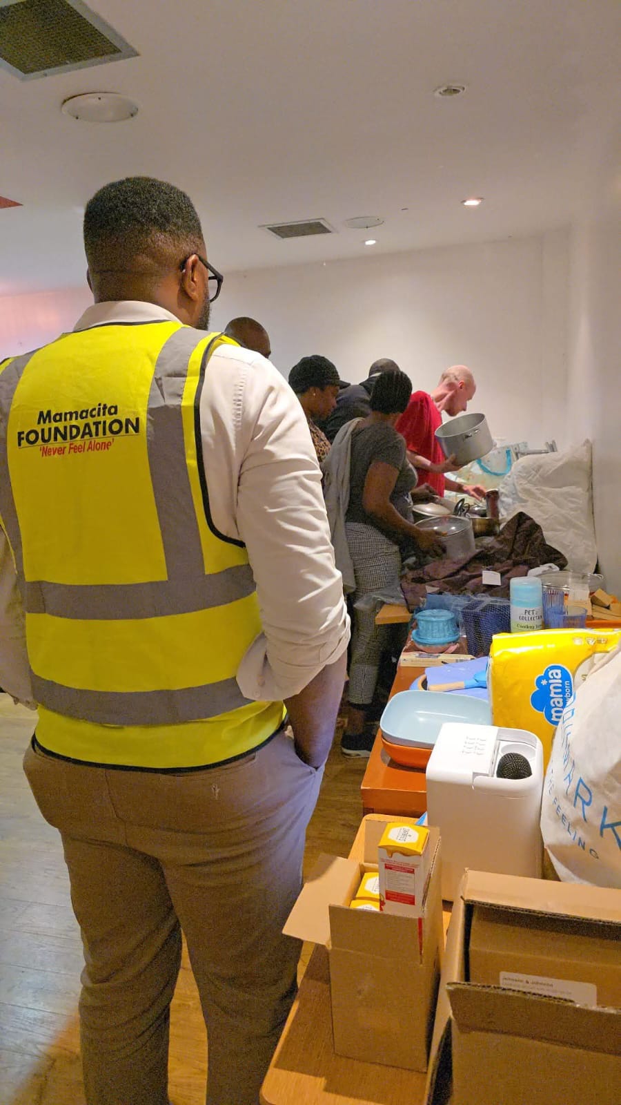 Volunteer in yellow Mamacita Foundation vest at food distribution event